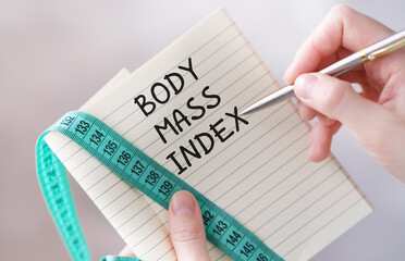 A person is writing on a notebook with a pen