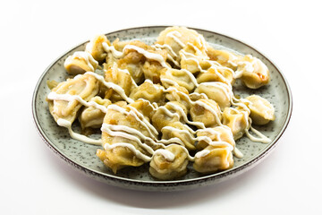 Homemade dumplings with fried onions on white background. Food concept
