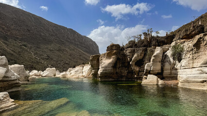 Obraz premium Explore the stunning beauty of Kalysan Canyon in Socotra with clear waters and majestic cliffs