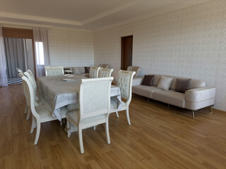White room with dining table with chairs for guests