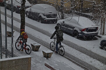 Moment of storm with strong wind and heavy snowfall on the street, and the cycling continues, Sofia, Bulgaria  