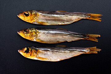 Hot smoked whole herrings on kitchen table. smoked fish isolated on a black background