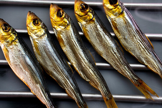 Hot smoked whole herrings on kitchen table. smoked fish isolated on a black background