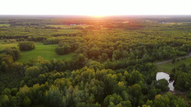 Flying over forest and small farms in Minnesota at Sunset