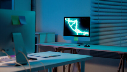 Desktop computer featuring a rotating DNA double helix on the screen, set in an empty office at...