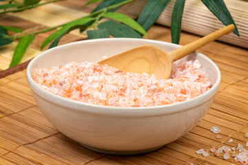 Coarse red Himalayan salt in bowl on bamboo mat