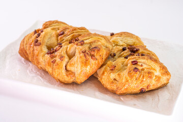 Fresh delicious puff pastry with maple syrup and nuts on white background