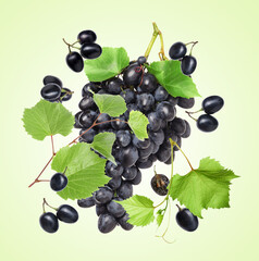 Fresh grapes in air on light green background