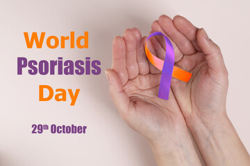 World Psoriasis Day (October, 29). Woman holding orange-orchid awareness ribbon on light background, top view