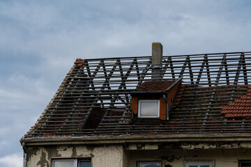 Roof renovation in progress on an old building under cloudy sky