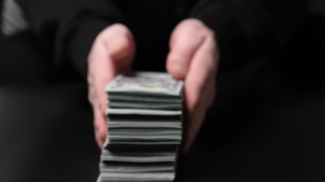 A man or a swindler, the swindler, rubbing his hands, takes the money for himself. Concept of robbery, deception, fraud and corruption