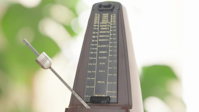 Vintage metronome in motion with pendulum swinging