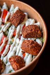 Falafel salad bowl. Vegan and vegeterian lunch plate - basmati rice with cucumber, tomate and falafel with white sauce.
