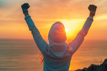 Woman celebrates sunrise victory on coastal cliff
