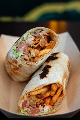 Breakfast falafel burrito wrap with fries, chicken and vegetables in a box. Tortilla wrap sandwich