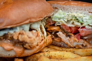 Close up of hamburger cut in a half with fries