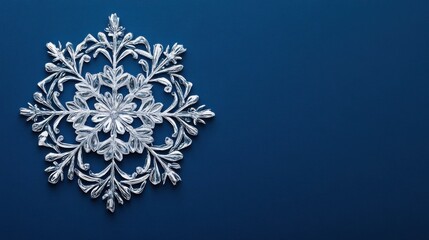 Silver snowflake ornament on blue background