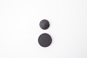 Recycled black plastic bottle caps arranged on white background, showing step in creative process.