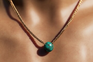 Elegant golden necklace features striking turquoise pendant, enh