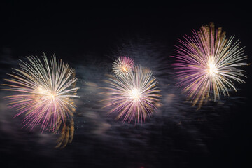 Multicolored Fireworks Exploding Over Water