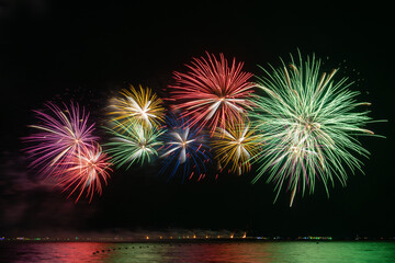 Multicolored Fireworks Exploding Over Water