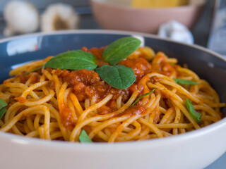 Balanesi pasta swimming in robust tomato sauce, garnished with verdant basil leaves, nestled in ceramic bowl - gourmet dining experience capturing mediterranean flavor profile