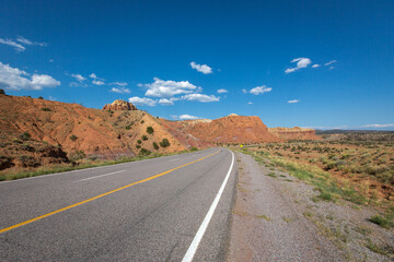Highway perspective in desert in New Mexico under blue sky