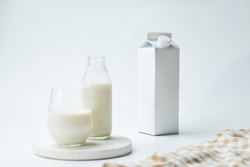 Milk Carton and Glass With Fresh Milk on a Simple White Background in a Bright Kitchen Setting