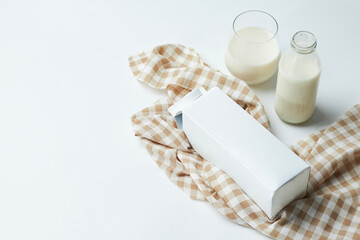 Milk Packaging and Servings With Glass and Bottle on Checkered Cloth Background