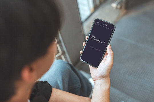 Artificial intelligence, AI chatbot assisting, man using mobile smartphone with live chat with chatbot and automatic messages