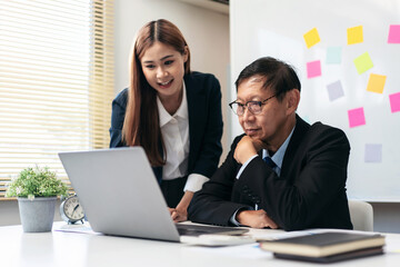 A man and a woman are working together on a laptop