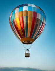 Naklejka premium Close-up de un globo aerostatico de colores volando aislado sobre un cielo azul símbolo de libertad, sueños, esperanza, superación y camino propio para marcas de viajes, motivación y creatividad