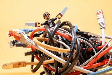 Naklejka premium Lego technician trying to fix a bunch of tangled ethernet cables. Illustrative editorial. January 20, 2025