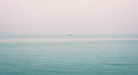 Fototapeta premium Solitary sailboat on calm sea under clear sky at dusk