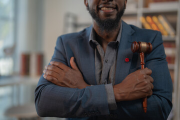 Confident lawyer holding a wooden gavel, smiling while crossing arms, embodying principles of...