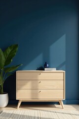Modern Light Wood Chest of Drawers Against a Deep Blue Wall with a Plant