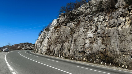 Mountain road curve under clear blue sky, adventure travel concept, landscape backdrop, scenic...