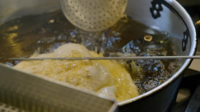Neapolitan street food: Frying panzarotti and pizza montanara in hot oil, showcasing the preparation of this traditional savory pastry