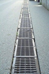 Obraz premium A Long Linear Drainage System in a Public Area A Perspective View of Parallel Metal Grates
