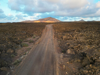 Lonely Dirt Road Through Volcanic Landscape Lanzarote’s Rugged Terrain & Lava Fields