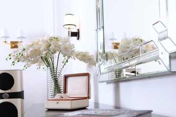 Decorative glass ball is in casket. Console table and rectangular mirror in modern interior....