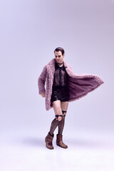 Full-length photo of man posing, dressed in striking leopard print coat and edgy accessories with...