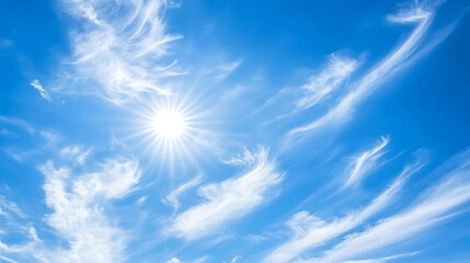 A clear blue sky with a bright shining sun and a few soft white clouds floating gently