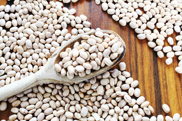 Obraz premium Pinto beans scattered on the wooden table. Carioca beans.