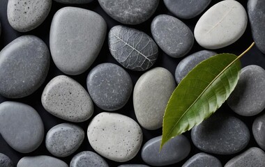A macro photo of gray stones and a leaf on a colorful background
