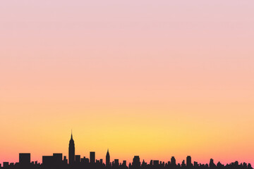 Fototapeta premium A city skyline is silhouetted against a pink and orange sky