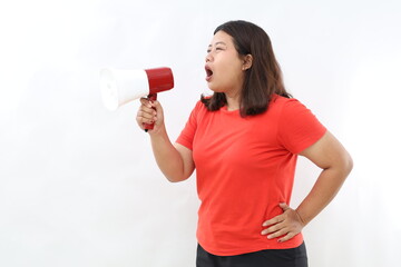 Happy beautiful Asian woman talking on megaphone to sideways isolated on white background