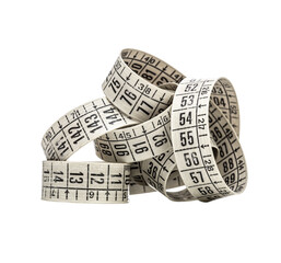 Close up of a coiled measuring tape, displaying various numerical measurements against a...
