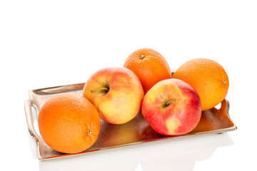Three sweet oranges and two apples on a metal tray, close-up, isolated on a white background.