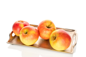 Four sweet apples on a metal tray, close-up, isolated on a white background.